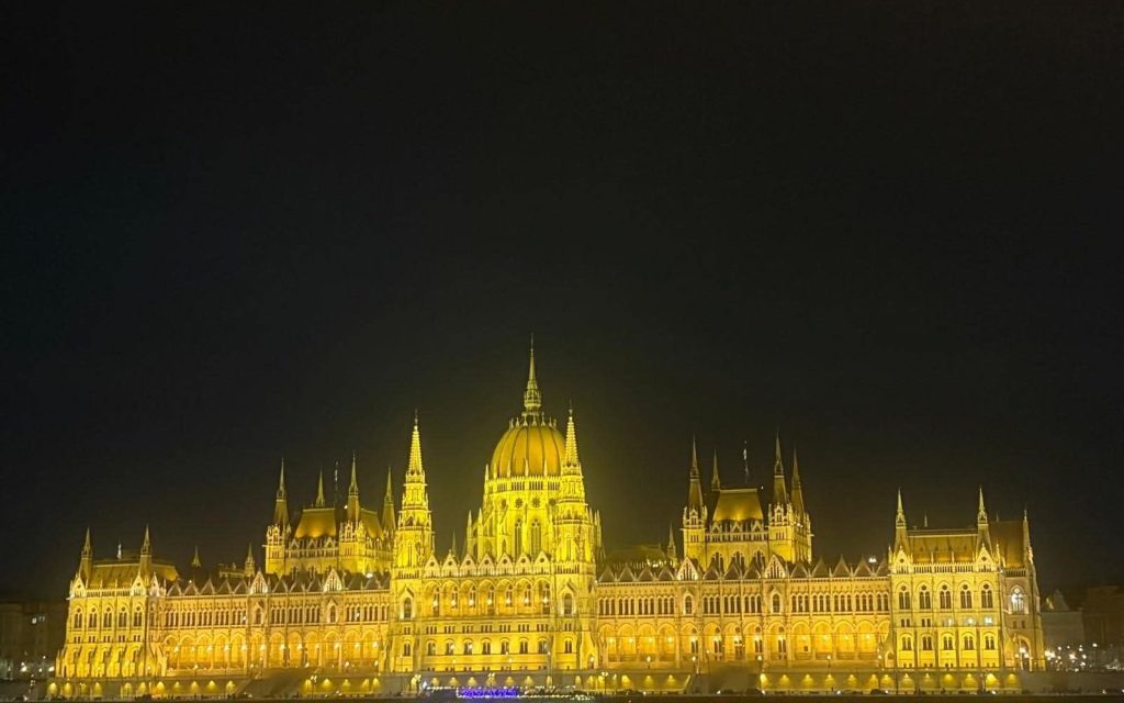 Hungarian Parliament illuminated beside the Danube at night in Budapest