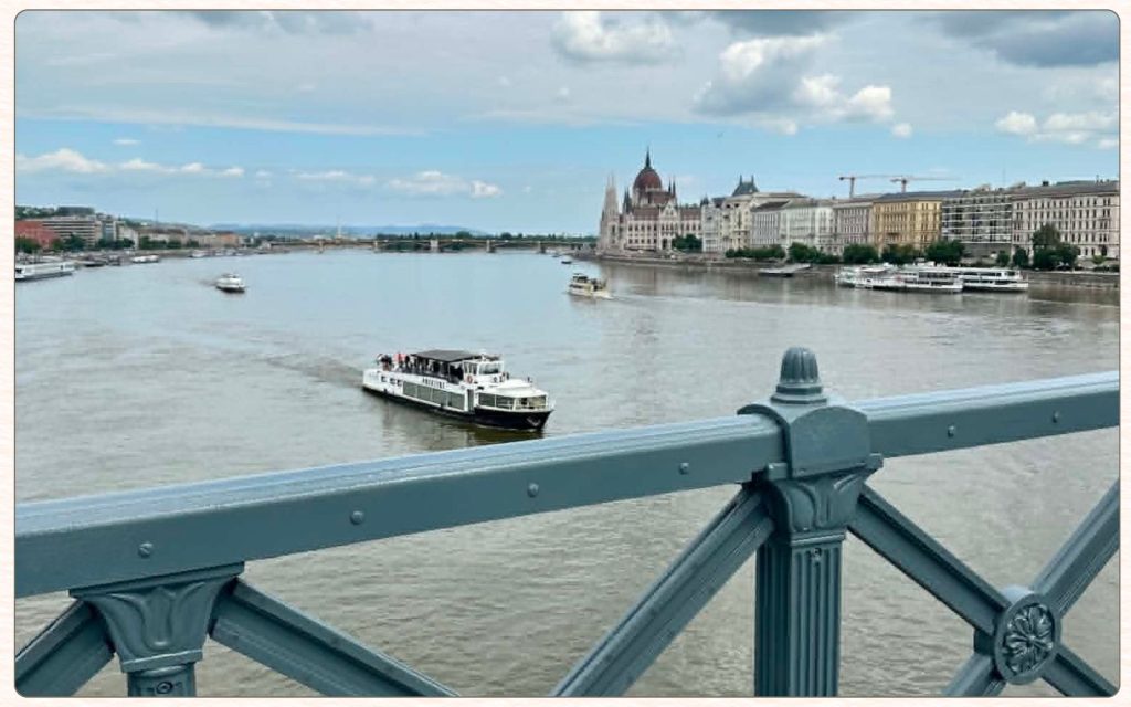 Danube river view with sightseeing boat and Parliament for planning Budapest itineraries

