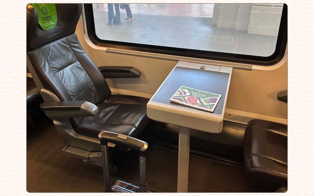 First-class Railjet seat with luggage during a train journey to Budapest